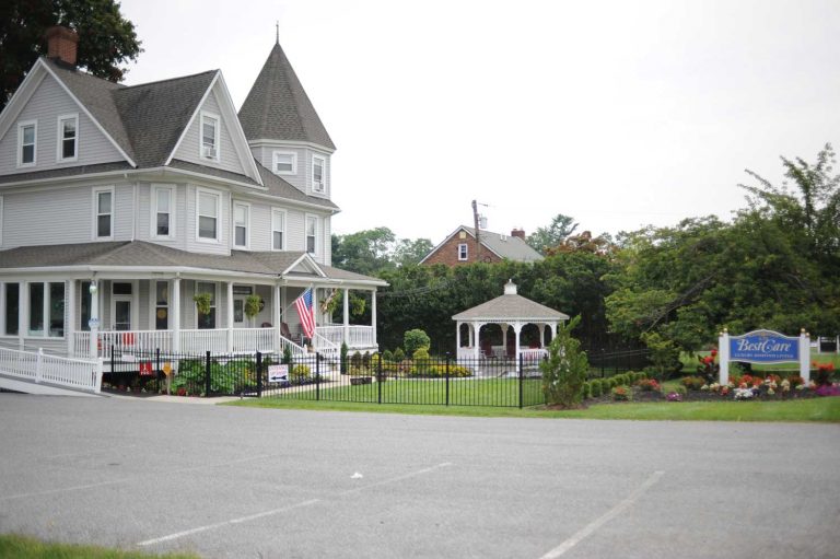 Large Victorian-style assisted living facility with a gazebo and a garden