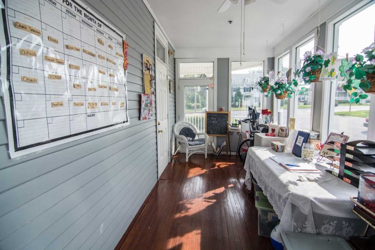 Activity schedule board and recreational area in an assisted living facility with natural light