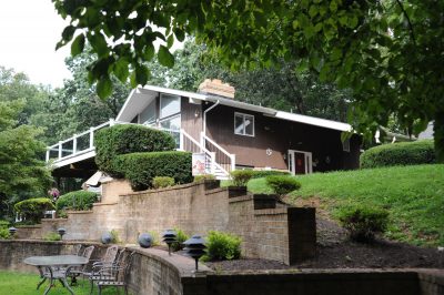 Exterior of an assisted living facility surrounded by trees and a spacious yard.