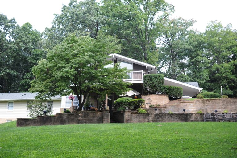 Exterior of an assisted living facility surrounded by trees and a spacious yard